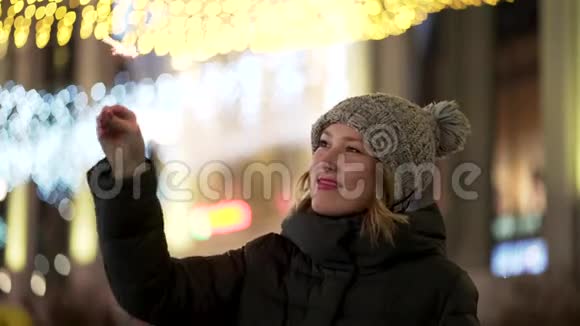 美丽开朗的女人晚上拿着火花模糊的城市灯光背景寒假的概念青年视频的预览图