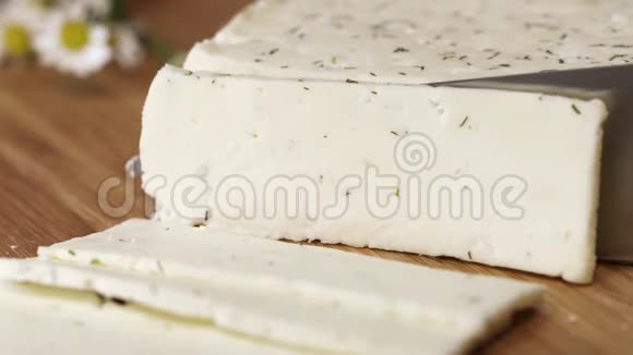 美味的白色小屋奶酪上面有刀片切割草药视频的预览图