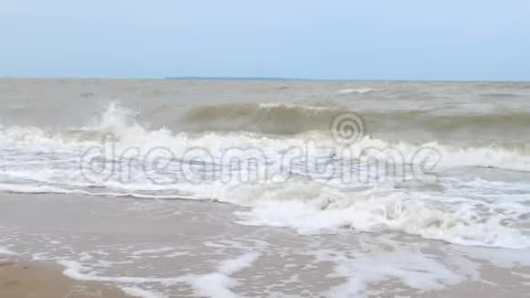 穿泳装的可爱女孩在海滩上玩波浪海上风暴强风强浪暑假视频的预览图