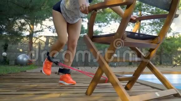 这个黑发女孩正在夏季训练腿部伸展动作动作缓慢滑块射击视频的预览图