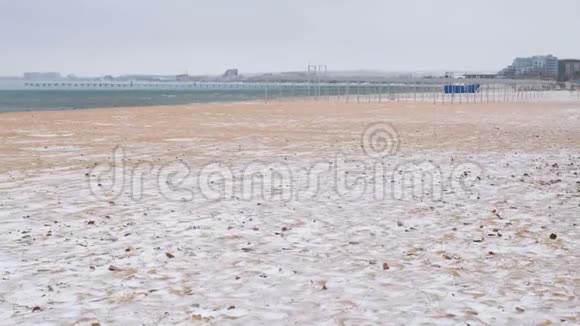 冬天的雪在海沙滩上背景是沿海城镇视频的预览图