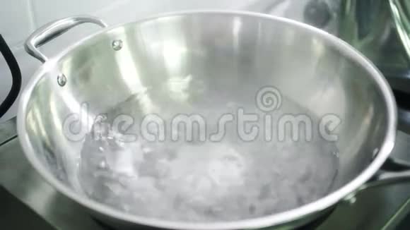 在一个大金属碗里的炉子上有把手水沸腾视频的预览图
