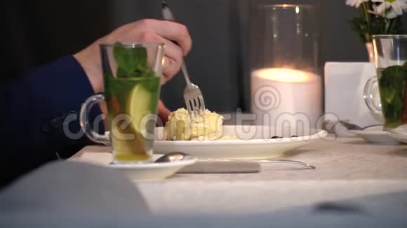 一个人在烛光下吃一个带叉子的蛋糕有点慢动作视频的预览图