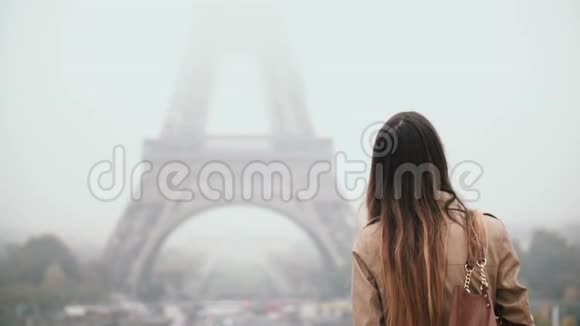 年轻迷人的女人独自在市中心散步在法国巴黎雾蒙蒙的早晨探索埃菲尔铁塔视频的预览图