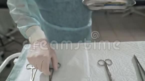 手术结束后外科医生从手术台上取出手臂上的医疗器械医生将无菌工具放入视频的预览图