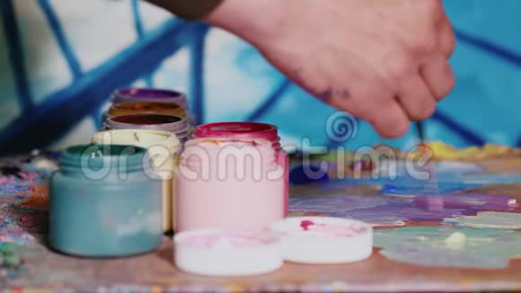 手工画家混合颜料旁边站着一罐油漆视频的预览图