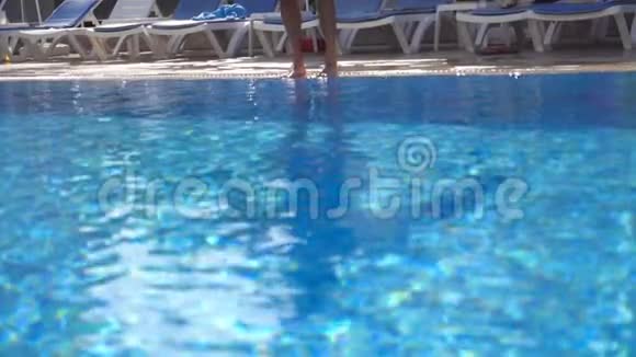 阳光明媚的日子肌肉发达的男人在盆里跳着年轻人在游泳池游泳暑假或假期视频的预览图