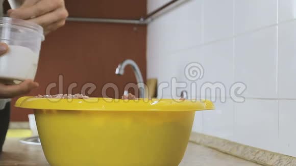 特写男在家厨房的黄盆子里手里拿着盐碎肉视频的预览图