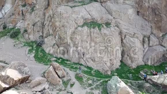 一名男性登山者爬上悬崖射击发生在空中的一侧为岩石植物打开了美丽的视野视频的预览图