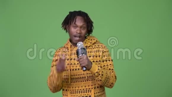 年轻英俊的非洲男子唱着麦克风视频的预览图