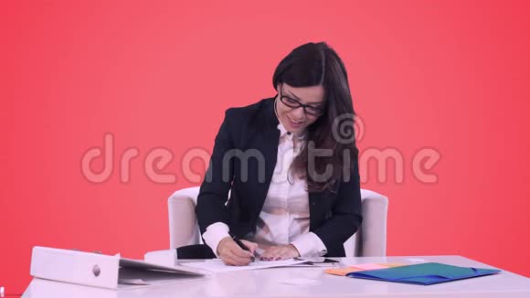 商务女性坐在办公室的办公桌前在文件上交给经理桌子上有视频的预览图