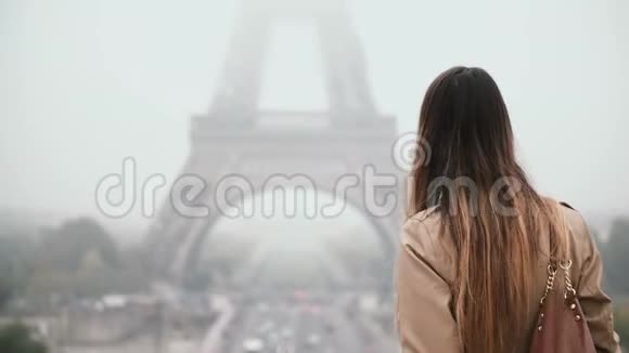 在法国巴黎市中心埃菲尔铁塔附近散步的年轻美女的后景探索市中心视频的预览图