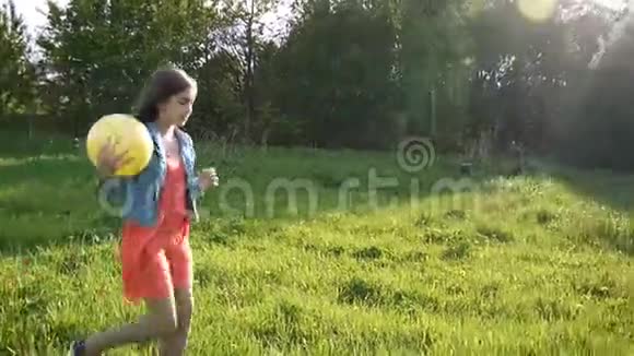 十几岁的女孩在夏天公园玩黄色的球视频镜头高清全景与稳定视频的预览图