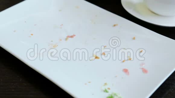 女的手特写用叉子的白色长方形盘子收集食物的残余物视频的预览图