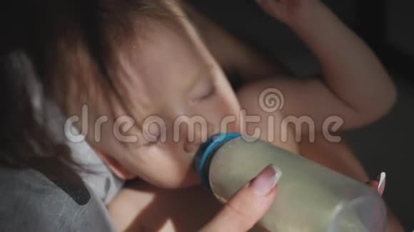 小男孩用瓶子睡着了可爱的小男孩从瓶子里喝牛奶关门视频的预览图