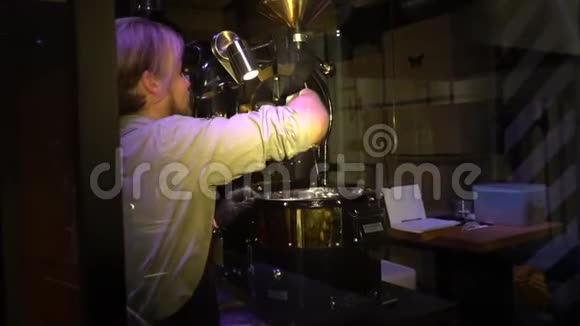 金发男咖啡师穿着统一薯条咖啡豆在一台特殊的机器上视频的预览图