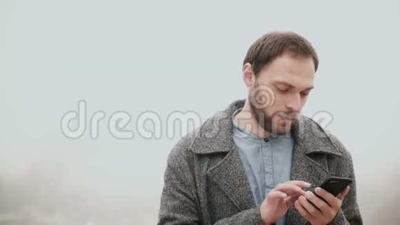 法国巴黎的雾天早晨帅哥使用智能手机与触摸屏附近的埃菲尔铁塔视频的预览图