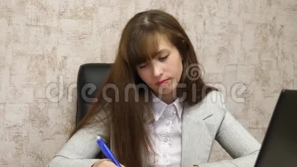 女商人坐在办公室的椅子上用电脑做笔记青年女企业家视频的预览图