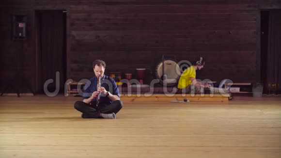 一个人坐在地板上吹笛子视频的预览图