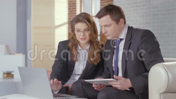 商务女士和男士检查笔记本电脑的演示文稿慢动作视频的预览图