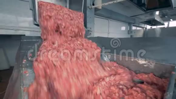 一堆肉被从一个小容器中丢弃到一个大的容器中在那里它被搅动视频的预览图