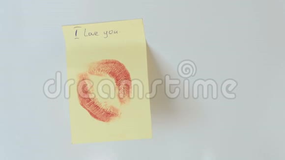注意亲吻和写作我爱你在墙上的黄色纸棒上视频的预览图