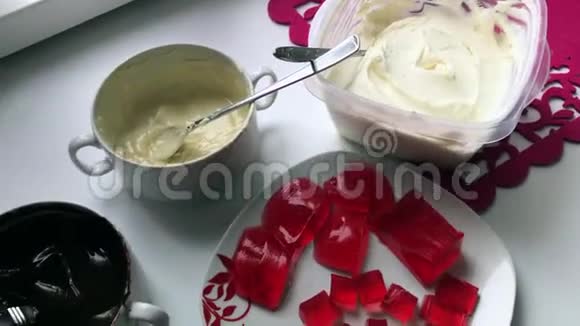 制作釉面凝乳棒的材料和用具一个女人用勺子混合融化的白巧克力视频的预览图