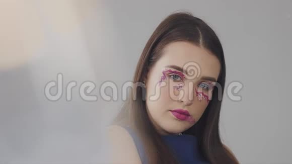 年轻模特在摄影棚用洋红色调化妆视频的预览图