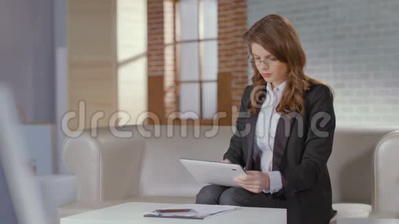 漂亮的商务女性使用平板电脑微笑的凸轮网上约会视频的预览图