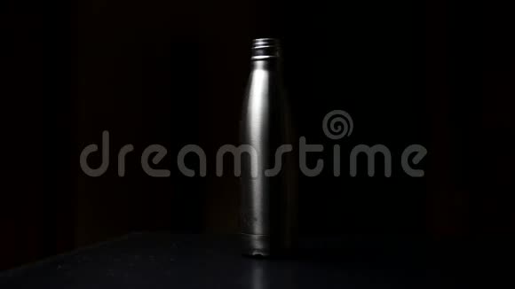 可重复使用的钢制热水瓶带盖在桌子上黑色工作室背景视频的预览图