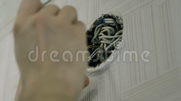 特写男用螺丝刀修理电器接线盒上的电线视频的预览图