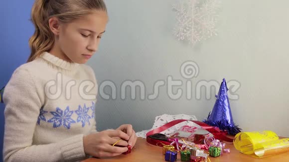 少女用彩色箔纸制作微型礼物视频的预览图