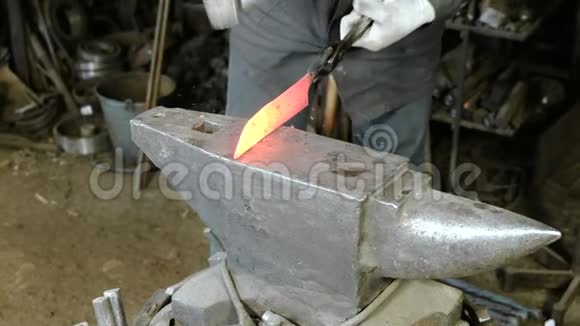 在锻造厂用金属制造刀紧紧抓住铁匠双手在铁锤上敲打铁水视频的预览图
