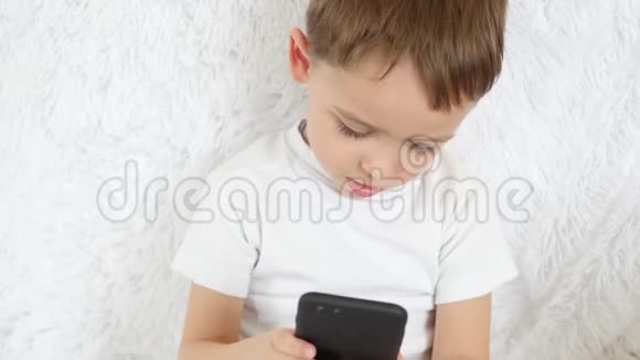一个孩子喜欢在白色背景下玩电话特写镜头视频的预览图