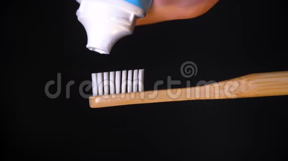 把牙膏从管子里挤到木制牙刷上视频的预览图