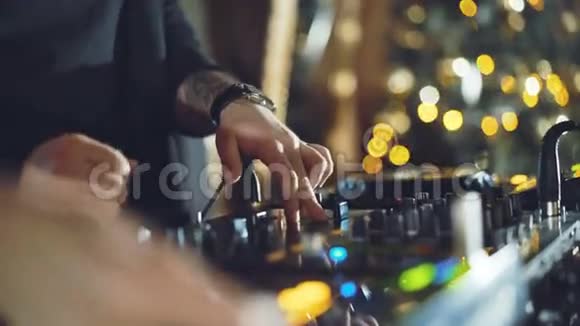 DJ手在4K中调整DJ甲板上的各种轨道控制装置视频的预览图