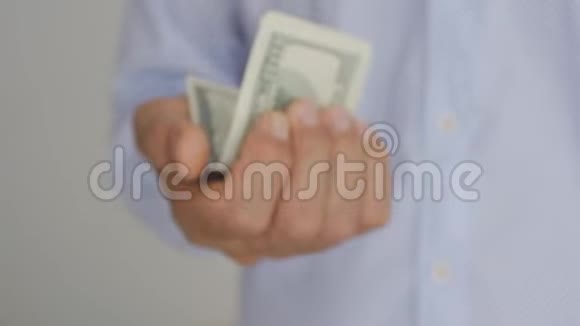 一个穿着浅蓝色衬衫的老人的手手里拿着百元钞票视频的预览图