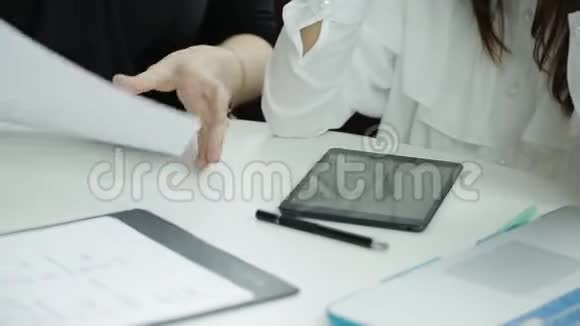 两个商务女性拿着文件工作一台笔记本电脑和一台平板电脑坐在桌子旁商务会议两个伙伴视频的预览图
