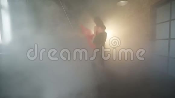 一对令人惊叹的夫妇在一个现代化的工作室里在烟雾中跳舞视频的预览图