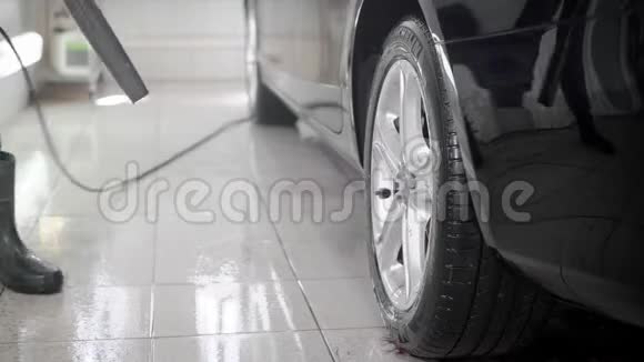 一名男子在洗车时用高压喷水冲洗汽车的特写镜头视频的预览图