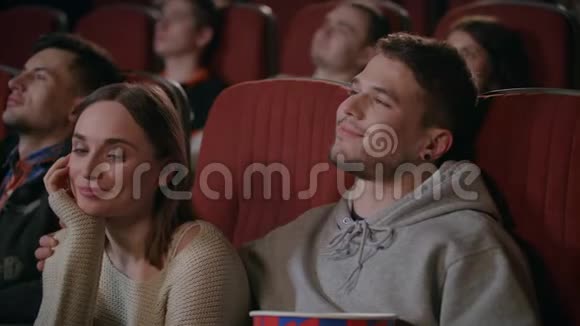 在电影院看电影的时候拥抱女孩爱情情侣欣赏电影视频的预览图
