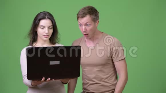 年轻女子使用笔记本电脑年轻男子看起来很震惊视频的预览图