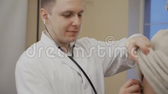 年轻医生用听诊器倾听老人的心声视频的预览图