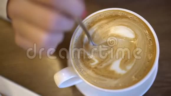 把糖混合到一杯拿铁咖啡里慢动作这位女士的双手白色混合糖和咖啡视频的预览图