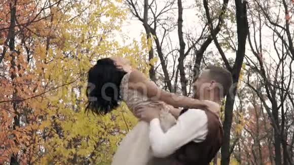 一个男人穿着西装抱着一个快乐的女孩穿着白色连衣裙慢动作的爱情故事视频的预览图