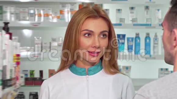 友好的女药剂师帮助药店的顾客视频的预览图