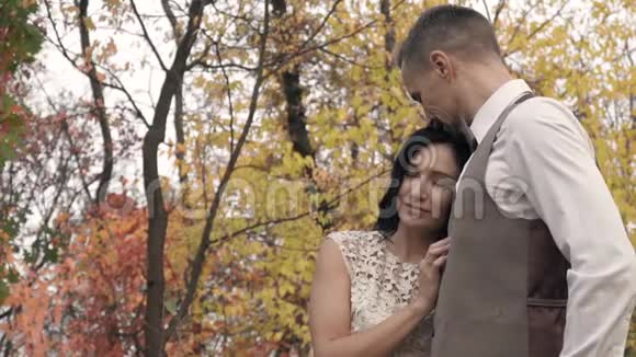 一男一女在一个秋天的公园里拥抱和享受寂静慢镜头拍摄视频的预览图