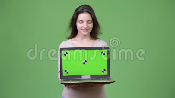 年轻快乐的美女展示笔记本电脑低头看视频的预览图