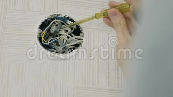 男人用螺丝刀修理电线在电气接线盒中寻找烧毁的电线视频的预览图