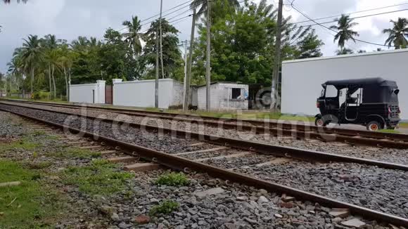 旅客列车在斯里兰卡日落时穿过居民区和丛林视频的预览图